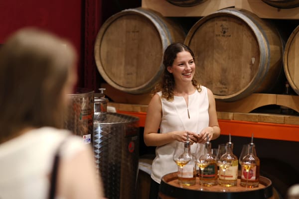 Gabrijela Brigljević smilin at her tasting room while educating people about liqueurs